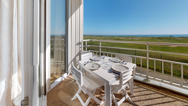 A balcony with a table set for dining, overlooking a coastal landscape. - Le Reflet Marin (Saint-Jean-de-Monts)
