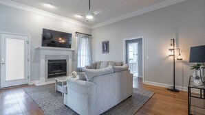 Uma sala de estar moderna com lareira, sofá, mesa de centro e abajur.