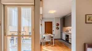 Un apartamento moderno con comedor, cocina y puerta corrediza de vidrio que da a un patio exterior.
