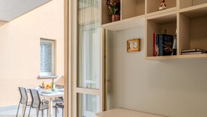 Una habitación moderna con comedor, estantería y ventana con vistas.