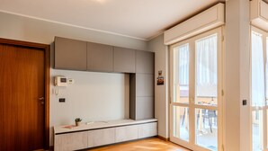 Una cocina moderna con horno empotrado, una pequeña encimera y suelo de madera.