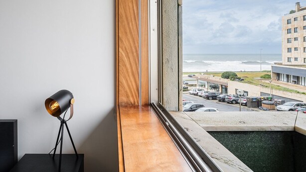 A room with a view of the ocean, a wooden window sill, and a lamp. - GuestReady - Serene hideout in Leça da Palmeira (Porto)