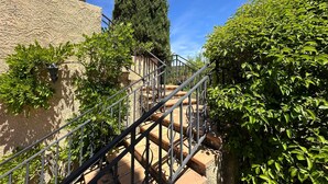 Una scala con ringhiere in metallo che conduce a un edificio con una parete strutturata.