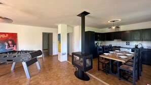 Una cucina moderna con mobili scuri, un'isola centrale e un camino a legna.