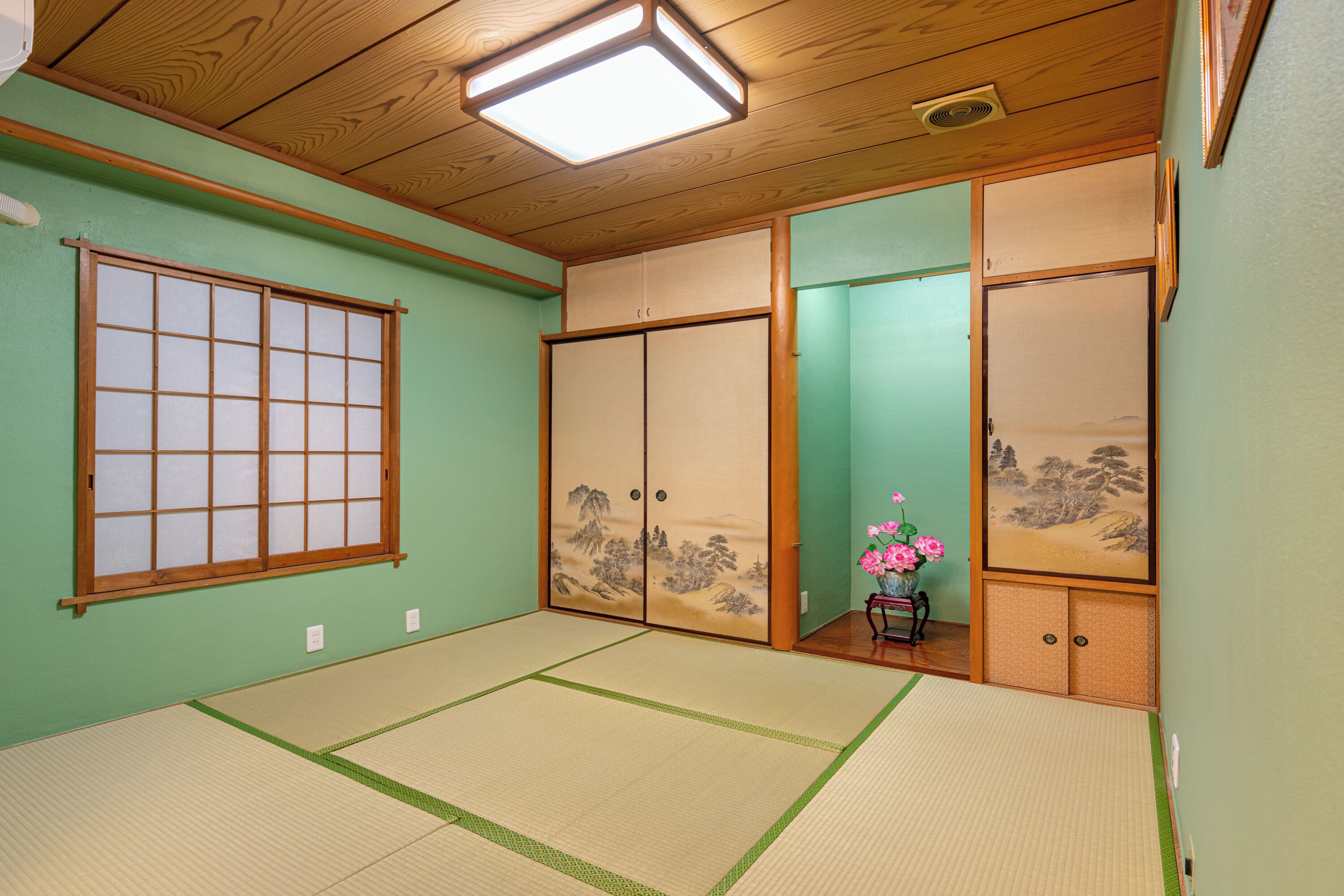 Une pièce de style japonais traditionnel, avec un sol recouvert de tatamis, des portes coulissantes et un paravent en papier de riz (shoji).