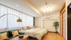 A hotel room with a large bed, a green sofa, a small table, and a potted plant. - Asakusa Temple 4min Skytree 10min Japanese Cozy House  (Tokyo)