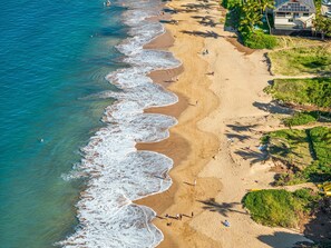 An aerial view of a beach with clear blue water, sandy shore, and a few people. - Maui Escape Near Beach, Pool & Hot Tub! - Maui Banyan H207 (Kihei)