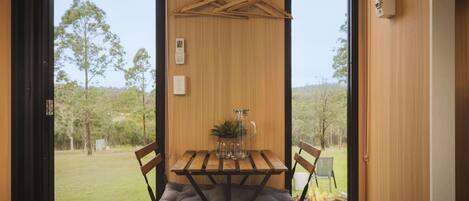 Un intérieur en bois avec une table, des chaises et un porte-manteau suspendu.