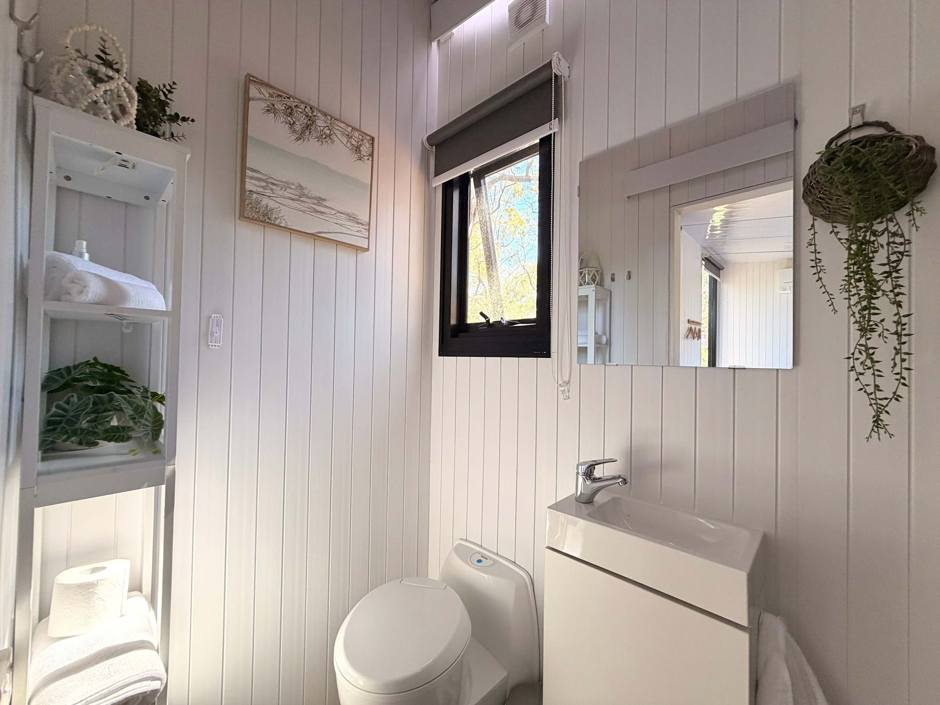 Un baño con inodoro, lavabo y ventana.