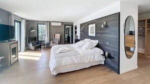 Une chambre moderne avec un grand lit, une télévision, un bureau et une chaise.