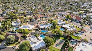 Un quartiere residenziale con case, piscine e palme.