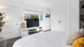 A bedroom with a bed, a television, a window, and a wardrobe. - 1950's Surf Shack - 6 min walk to beach! (Santa Cruz)