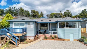 A two-story house with a covered porch, a small outdoor seating area, and a staircase leading to a deck. - 2 Bedroom Aptos Home With Ocean View! (Aptos)