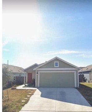Stylish single-story home with a garage and a small front porch, set amidst a quiet suburban neighborhood.