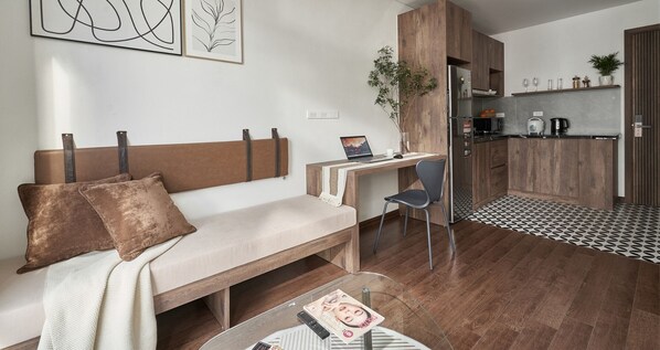 A modern living room with a sofa, a desk, and a coffee table. - The First May (Hanoi)