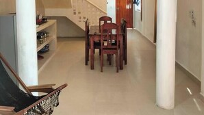 Un'ampia zona giorno con tavolo e sedie, una scala e un canestro da basket.