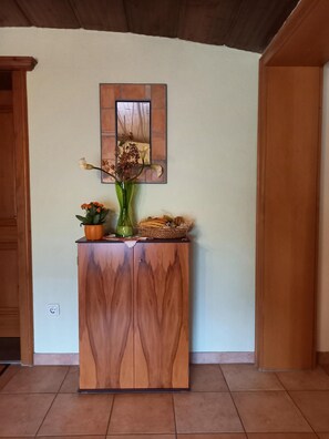 A stylish cabinet with a mirror above, complemented by a natural wood finish and decorative accents.