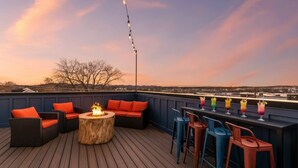 A rooftop deck with outdoor seating, a fire pit, and a bar area with colorful drinks. - Nashville house near Geodis Park with hot tub, game room, sleeps 12 (Nashville)