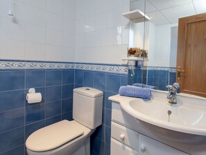 Une salle de bain avec des toilettes, un lavabo et une porte en bois.