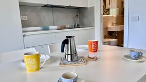 A modern kitchen with a white countertop, a stainless steel kettle, and two mugs with motivational phrases. - Casa San Michele a Bagnaia (Portoferraio)