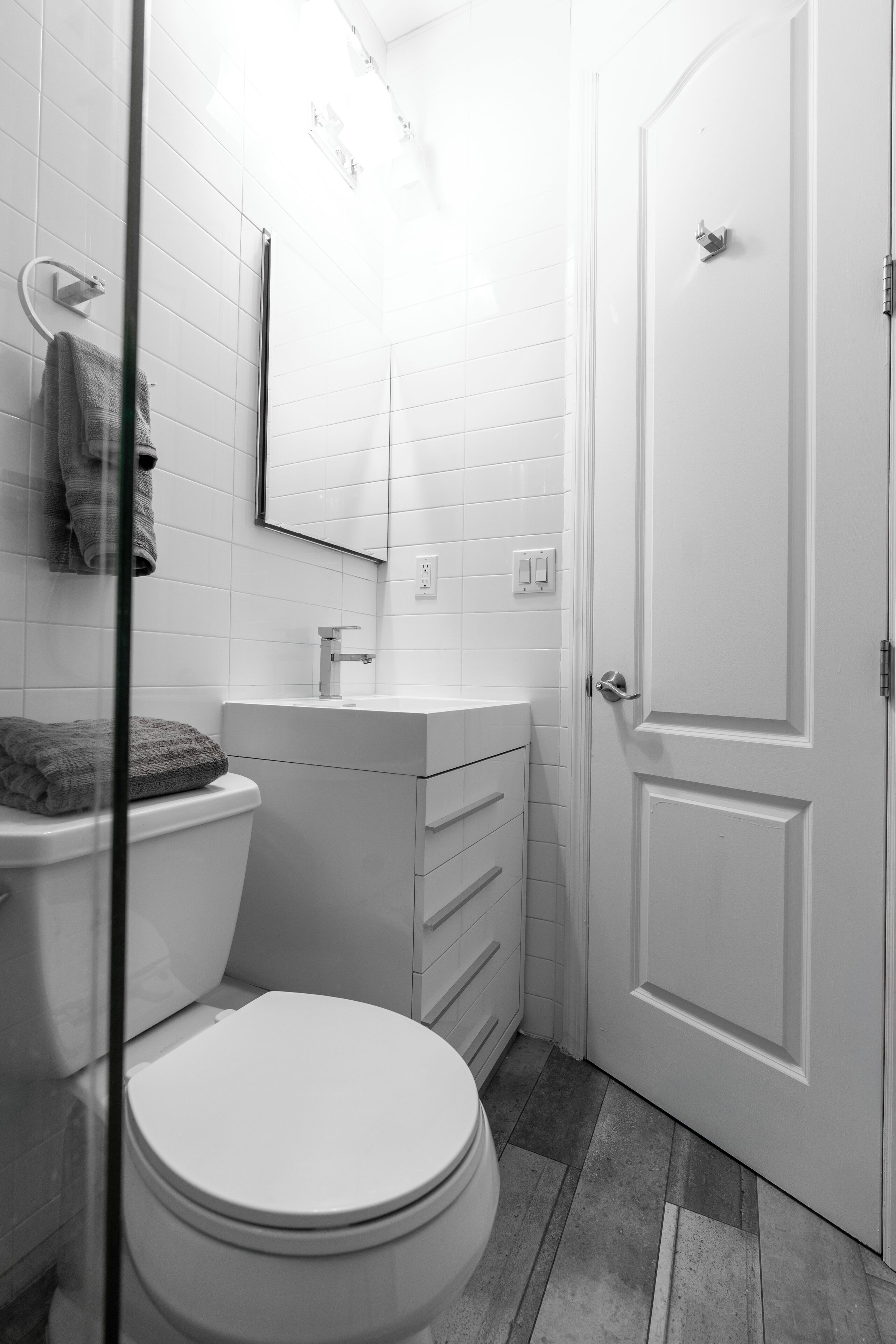 A compact bathroom with a white toilet, a sink, and a mirror above it.