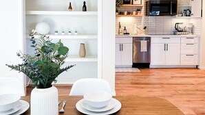 Une cuisine moderne avec des meubles blancs, un four à micro-ondes et un lave-vaisselle.