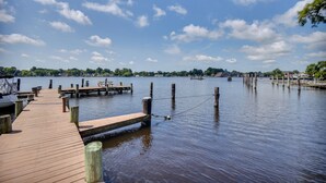 Une jetée en bois s’étendant sur une étendue d’eau calme, sous un ciel dégagé.