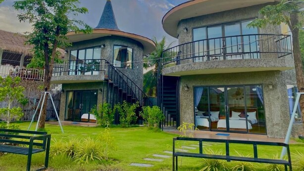 A modern building with two levels, large windows, and a balcony. - Finance Boutique (Kampot)