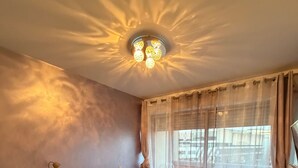 Una camera da letto con un letto, una scrivania, una sedia e un lampadario.