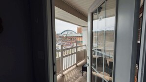 Un balcon donnant sur un bâtiment surmonté d’un dôme et sur un parking.
