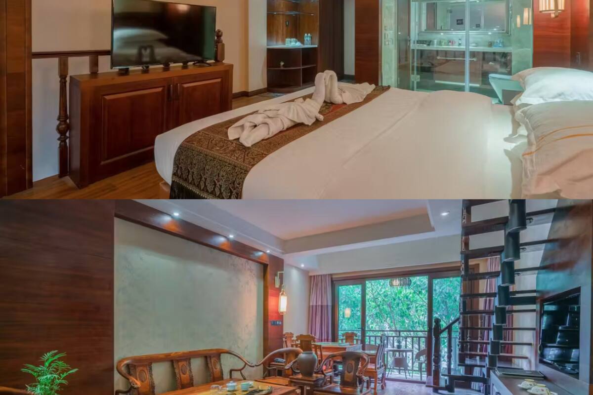A hotel room with a large bed, a television, a minibar, and a bathroom with a glass shower.