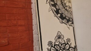 Una pared con un diseño de ladrillo blanco y una obra de arte floral en blanco y negro.