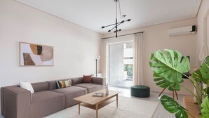 Un salon moderne avec un canapé, une table basse et une grande plante verte.