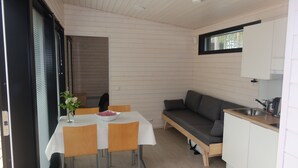 A compact kitchen with a dining table, a sofa, and a window. - Pistohiekka Resort (Puumala)