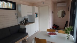 A compact living space with a kitchenette, a dining area, and a seating area. - Pistohiekka Resort (Puumala)