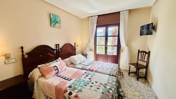 Une chambre avec deux lits, une fenêtre avec des rideaux, une chaise et un tableau accroché au mur.
