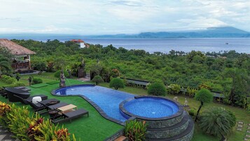 Una piscina con vistas al mar y a las montañas.