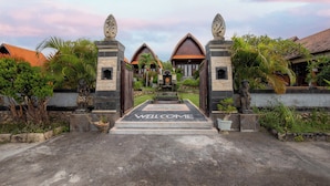 A traditional entrance with a 'WELCOME' sign, stone pillars, and tropical plants. - Reynten Hill  (Penida Island)