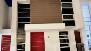 Un bâtiment moderne à deux étages, avec une porte rouge, le numéro 32, et de grandes fenêtres.