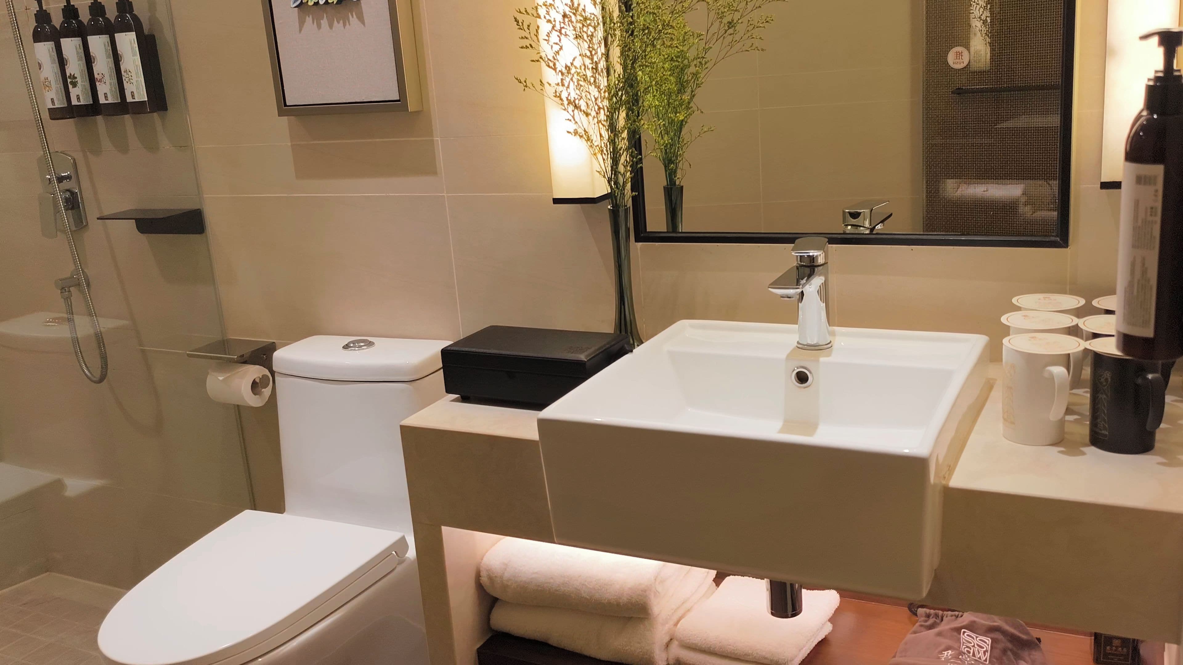 Un baño moderno con inodoro, bidé, lavabo y espejo.