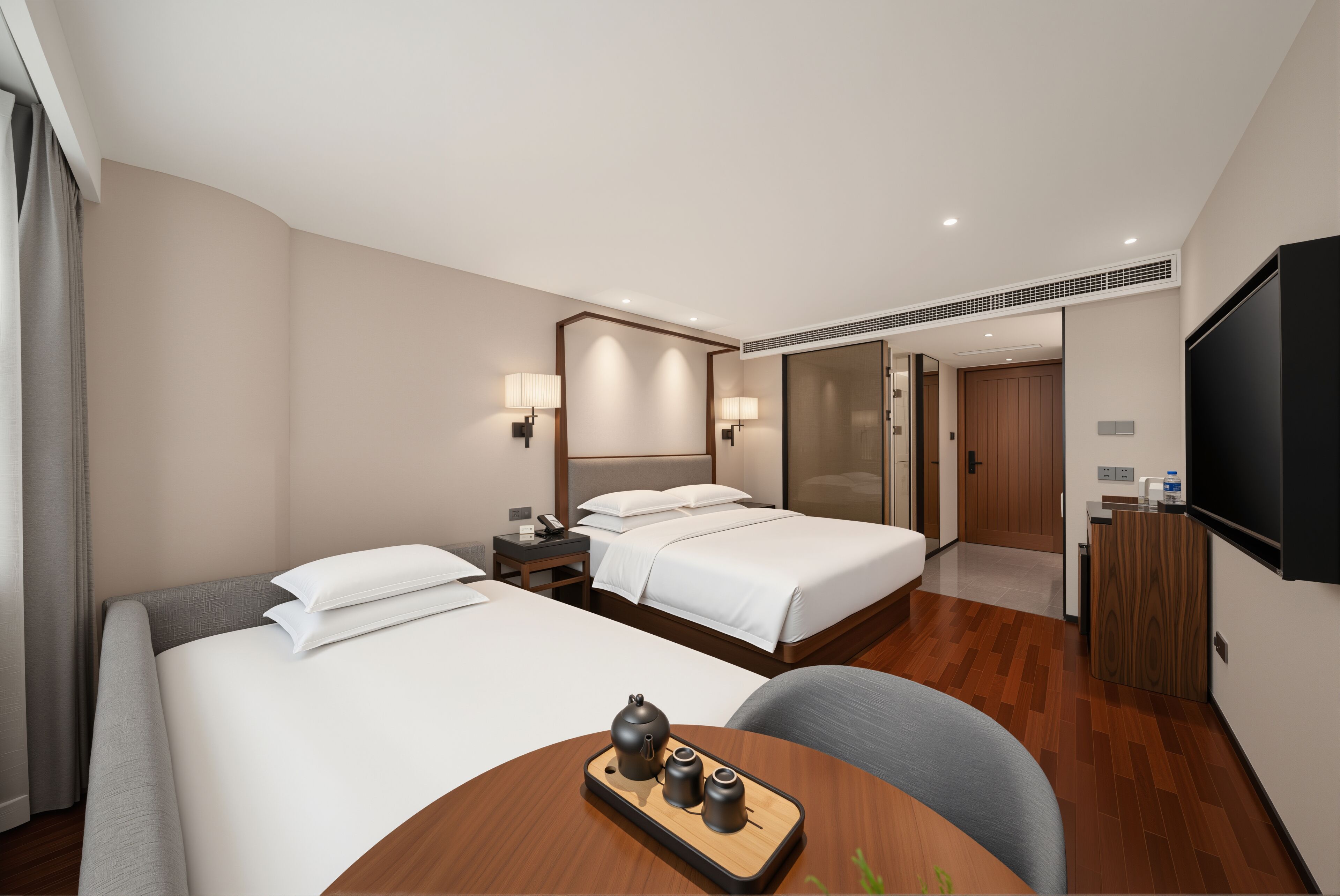 A hotel room with two beds, a desk with a chair, a TV, and a wooden table with a tray.