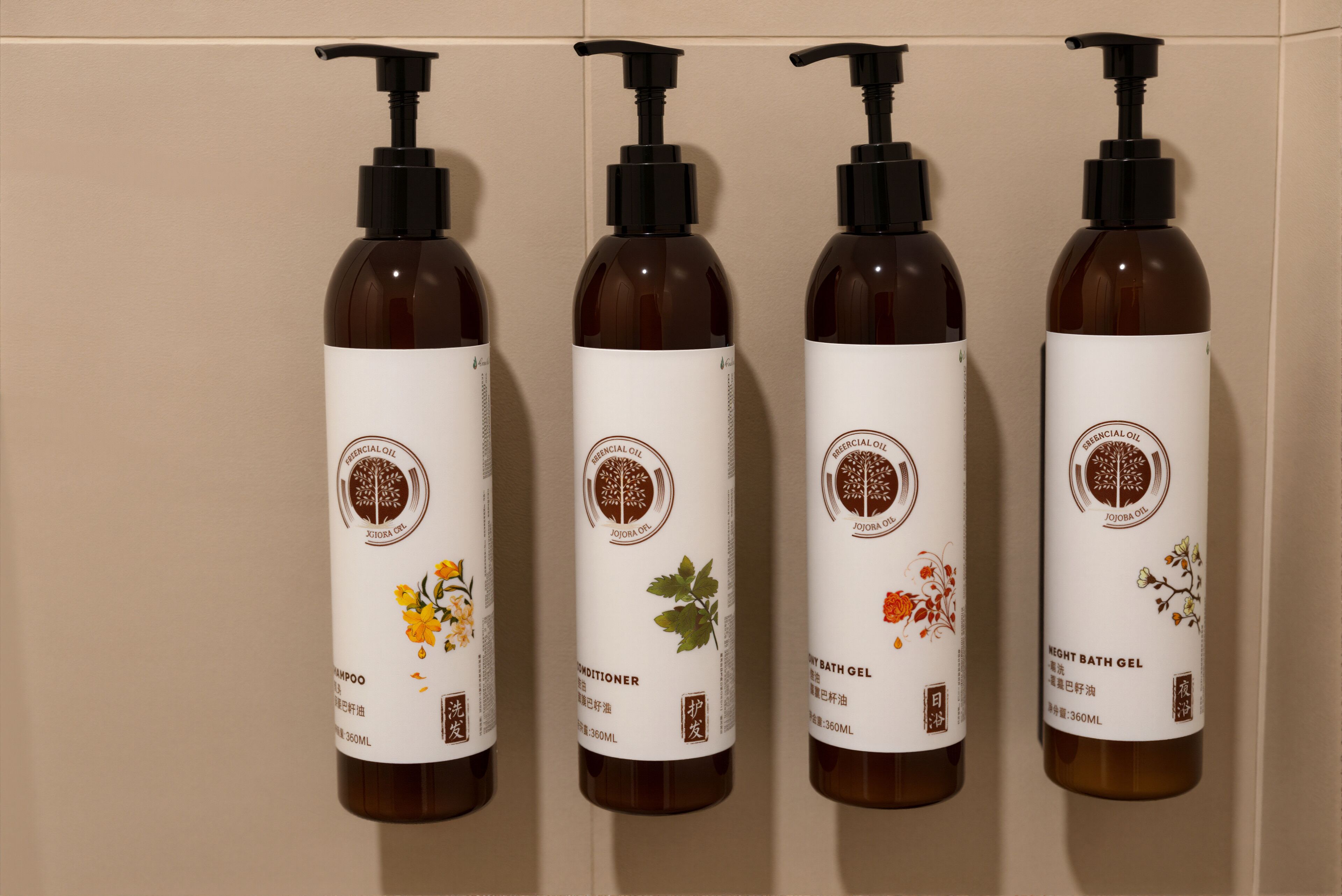 Cuatro botellas de productos de aceites esenciales con atomizadores, dispuestas en fila sobre un fondo neutro.