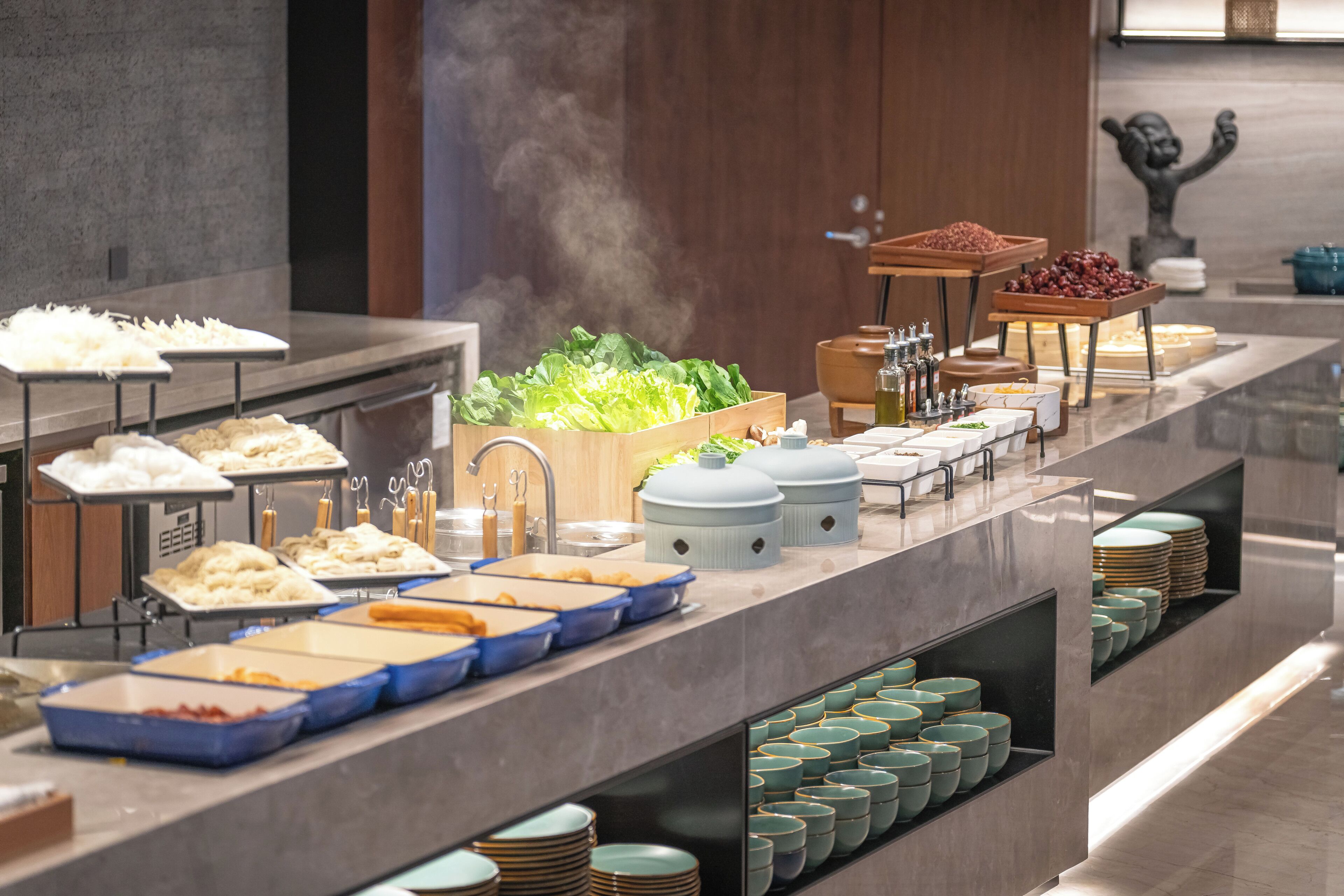 Un buffet proposant une variété de plats et d’ustensiles de service.