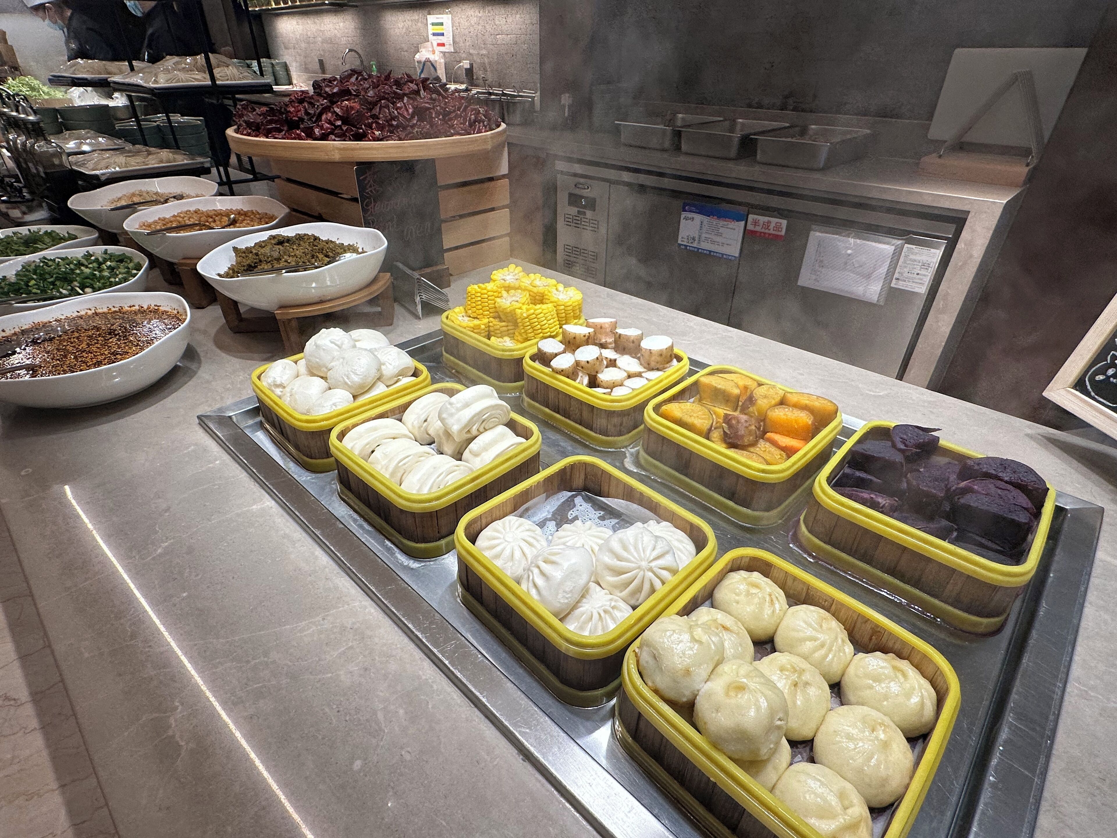 A buffet with various food items including dumplings, corn, and other dishes.