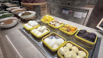 A buffet with various food items including dumplings, corn, and other dishes.