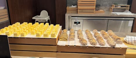 Ein Buffet mit verschiedenen Speisen, darunter Brötchen und einer Auswahl an Desserts.
