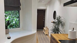 Une cuisine moderne dotée d’un plan de travail en bois, d’un four encastré et d’une fenêtre donnant sur un paysage verdoyant.