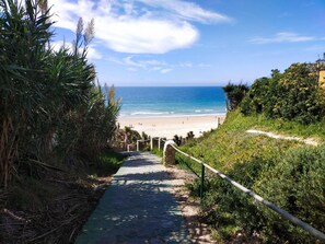 A pathway leading to a beach with a clear view of the ocean. - Suite Las Adelfas in Conil de la Frontera (Conil de la Frontera)