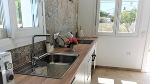 A modern kitchen with a stainless steel sink, a built-in oven, and a window providing natural light. - Suite La Morera in Conil de la Frontera (Conil de la Frontera)
