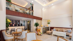A spacious lobby with a reception desk, seating area, and a balcony.